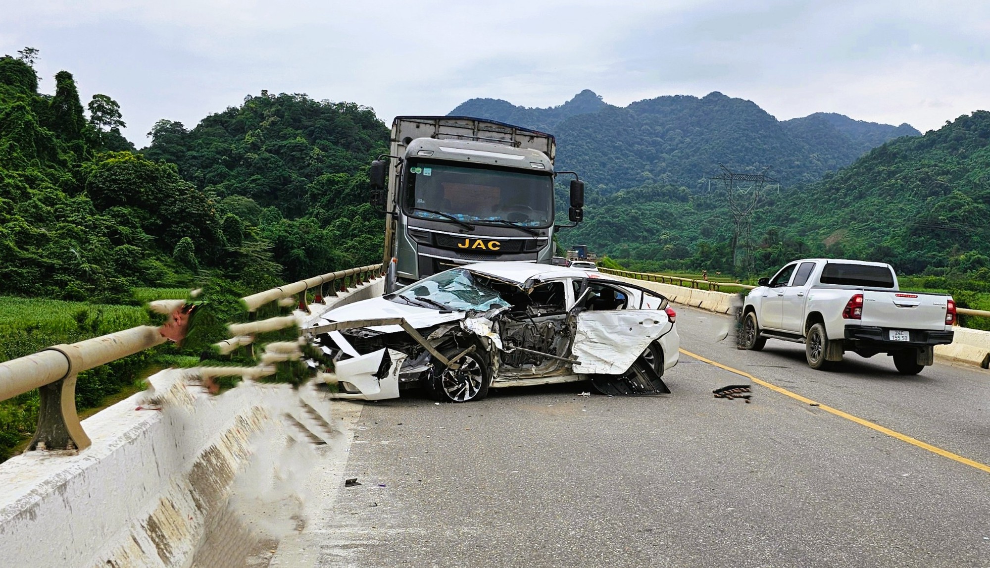 Tông nhau trên cầu, xe tải văng xuống vực, tài xế ô tô con tử vong, 5 người khác bị thương- Ảnh 1.
