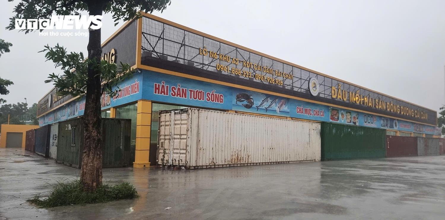 Người dân Quảng Ninh chặn bão Wipha bằng container và xe tải trước cửa hàng hải sản - Ảnh 1.