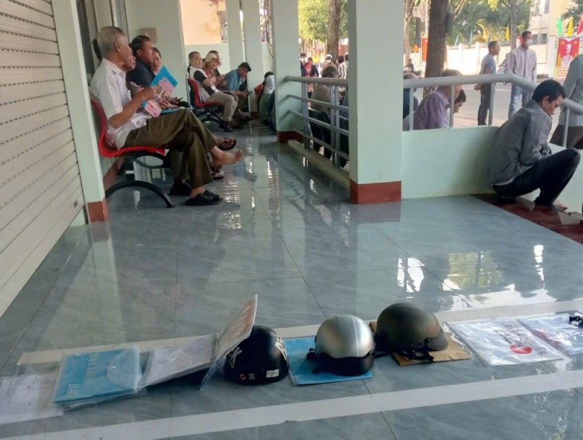 Người dân dùng mũ bảo hiểm để giữ chỗ nộp hồ sơ tại xã Ea Kar Đắk Lắk - Ảnh 1.