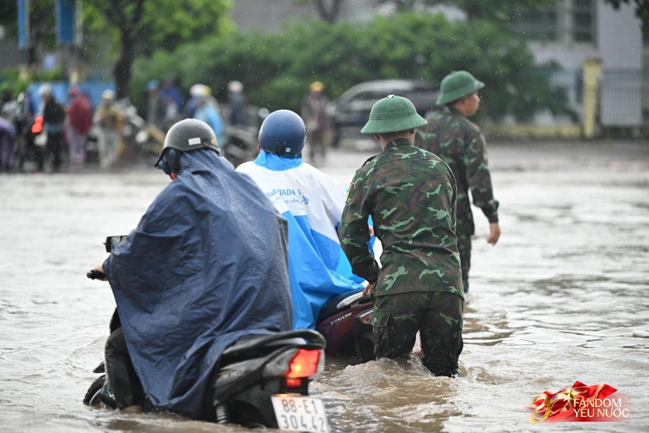 Ảnh đẹp sáng nay: Các chiến sĩ làm nhiệm vụ A80 lội nước đẩy xe, dìu dân qua đoạn ngập sâu ở Hà Nội- Ảnh 2.