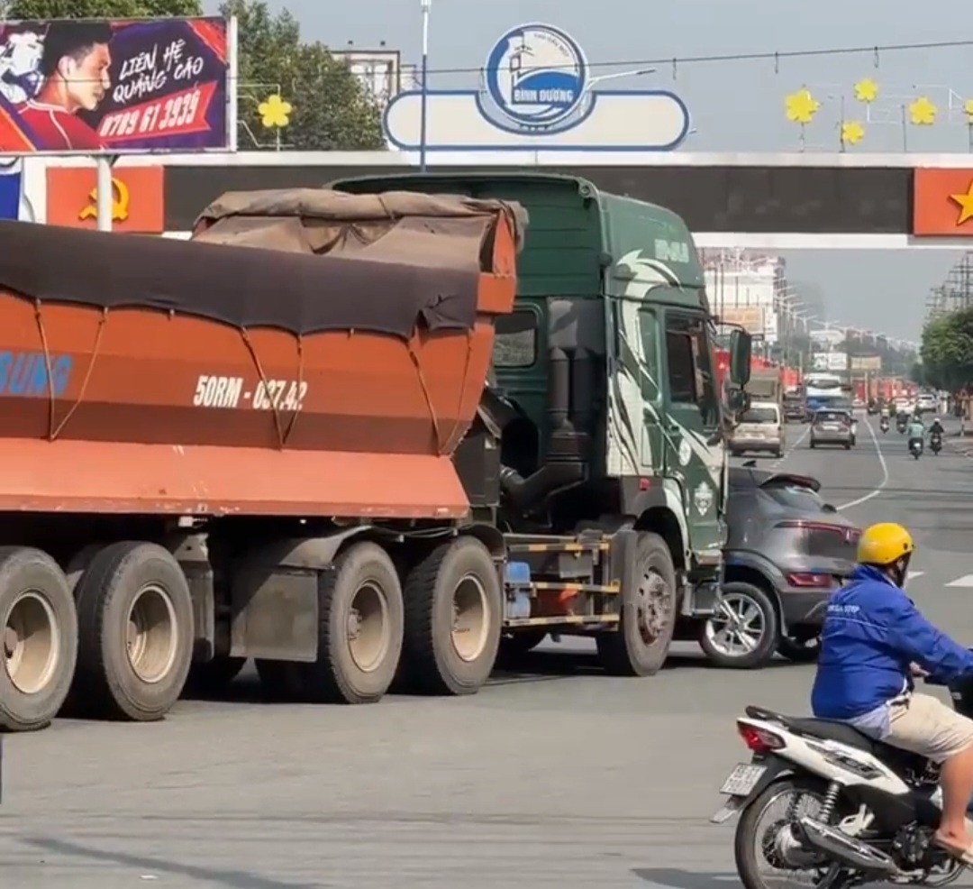 Xe bồn đẩy ô tô biển vàng tại vòng xoay Gò Đậu trên Quốc lộ 13 - Ảnh 1.