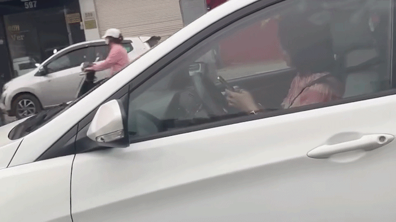 Nữ tài xế dùng 2 tay bấm điện thoại trong lúc đang lái xe trên phố Hà Nội - Ảnh 1.