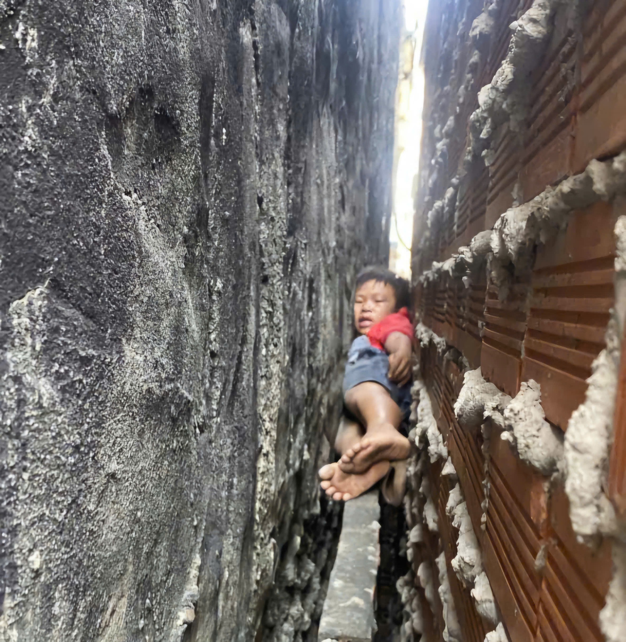 Giải cứu b&eacute; trai mắc kẹt giữa hai bức tường ở TPHCM chỉ sau 20 ph&uacute;t - Ảnh 1.