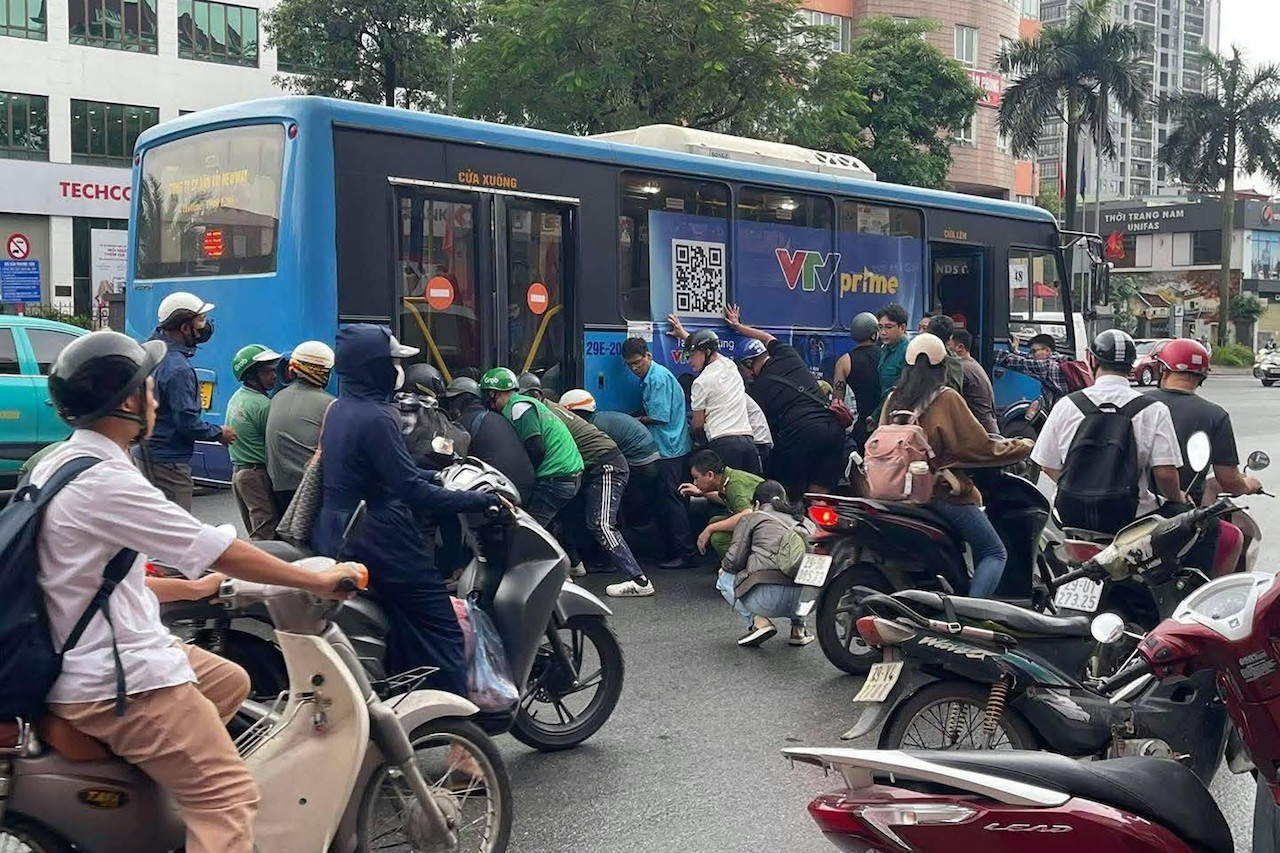 Gần 20 người n&acirc;ng xe bu&yacute;t cứu người phụ nữ mắc kẹt dưới gầm - Ảnh 1.