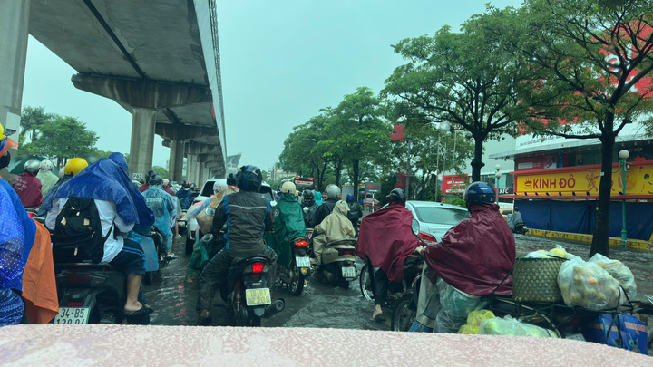 Hà Nội ngập nước khiến phụ huynh vất vả đưa con đến lớp giữa dòng nước mưa - Ảnh 1.