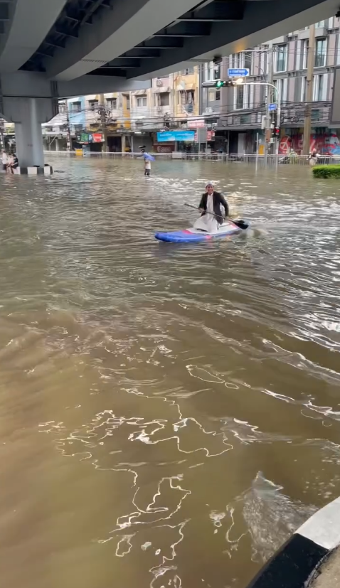 Ngập lụt Bangkok: H&agrave;i hước Khoảnh khắc ch&egrave;o thuyền vượt đ&egrave;n đỏ giữa phố - Ảnh 1.