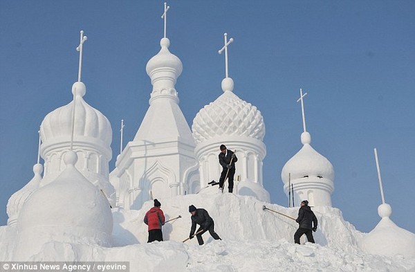 Craft: Workers carefully shape one of the dazzling snow sculptures in time of the opening of this year's event