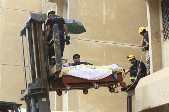 Khaled Mohsin Shairi, nặng 590 kg được khỏi nhà bằng xe nâng để tới bệnh viện điều trị ở Jizan, Ả-rập Saudi.