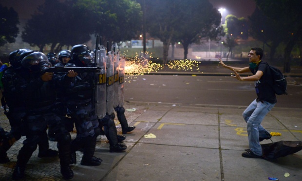 Cảnh sát chống bạo động bắn đạn cao su vào một nam thanh niên tham gia biểu tình phải đối kế hoạch tăng giá vé phương tiện công cộng tại thành phố Rio de Janeiro, Brazil.