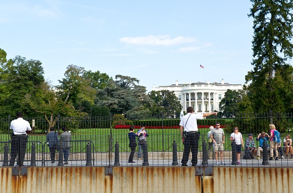	Nhân viên mật vụ mặc thường phục quan sát khách du lịch đứng bên ngoài Nhà Trắng tại Washington D.C.