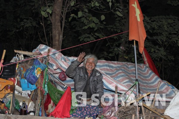 Ông Tuấn cùng chiếc lều dựng chông chênh bên mé đường cạnh gốc cây là nơi ăn ngủ của ông suốt 4 năm nay.