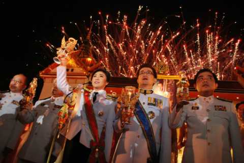 Thủ tướng Thái Lan Yingluck Shinawatra thắp nến mừng sinh nhật nhà vua. Ảnh: AP
