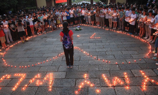 Các học sinh tại trường trung học Giang Sơn ở thành phố Cù Châu thuộc tỉnh Chiết Giang của Trung Quốc, thắp nến trên sân trường để tưởng niệm các nạn nhân trong vụ tai nạn máy bay ở San Francisco, Mỹ.
