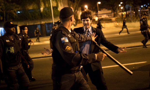 Cảnh sát chống bạo động đẩy một người biểu tình ở Rio de Janeiro, Brazil.