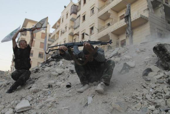 Các chiến binh phiến quân xả súng trong cuộc giao tranh với quân đội chính phủ tại thành phố Aleppo, Syria.