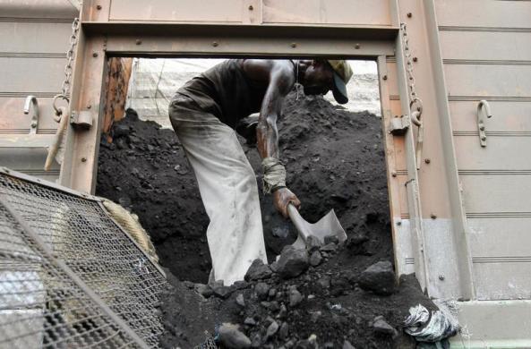Một công nhân xúc than khỏi một xe tải ở thành phố Ahmedabad, Ấn Độ.