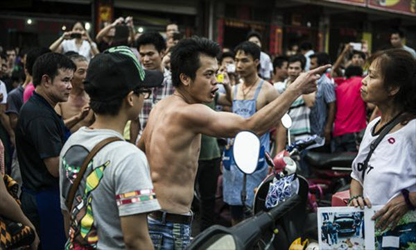 Một chủ nhà hàng thịt chó phản ứng dữ dội với người biểu tình bảo vệ động vật ở Ngọc Lâm, khu tự trị dân tộc Choang Quảng Tây, Trung Quốc.