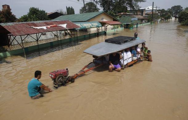 Chiếc máy kéo chời người dân bị chết máy trên đường ngập nước ở Candaba, Pampanga, Philippines.