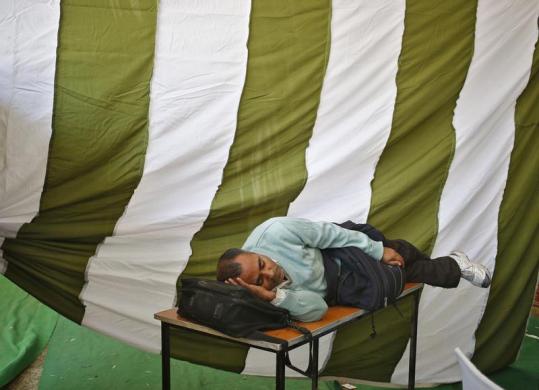 Một nhân viên bầu cử nằm ngủ tại một trung tâm huấn luyện bầu cử ở New Delhi, Ấn Độ.