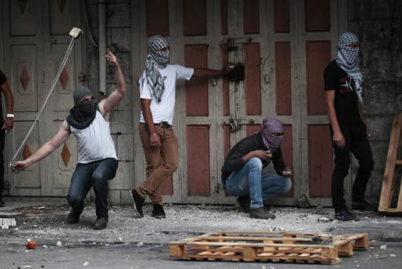 Một người biểu tình Palestin dùng dây để ném đá trong cuộc đụng độ với nhân viên an ninh Israel tại thành phố Hebron, Bờ Tây.