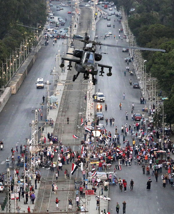 Một chiếc trực thăng quân sự bay trên đường phố gần phủ tổng thống Cairo, Ai Cập.