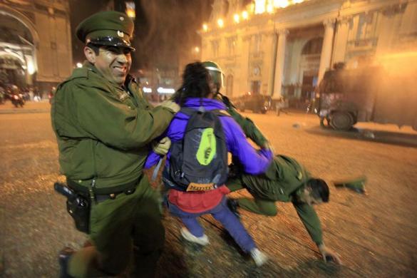 Cảnh sát bắt giữ một người biểu tình ở thành phố Santiago, Chile.