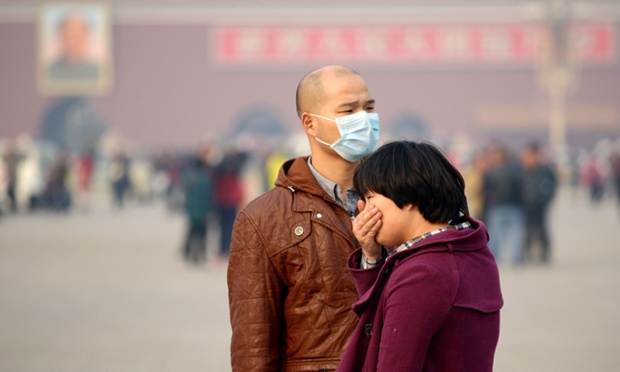 Du khách che miệng do không khí ô nhiễm khi tham quan quảng trường Thiên An Môn ở Bắc Kinh, Trung Quốc.