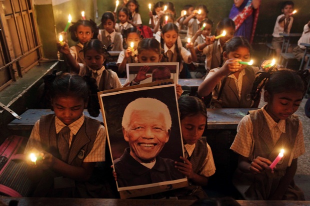Học sinh Ấn Độ thắp nến và di ảnh của cựu Tổng thống Nam Phi Mandela trong lễ cầu nguyện cho ông tại một trường học ở Ahmadabad.