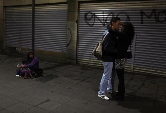 Một cặp đôi ôm nhau tình tứ cạnh những người ăn xin trên đường phố ở Mexico City, Mexico.