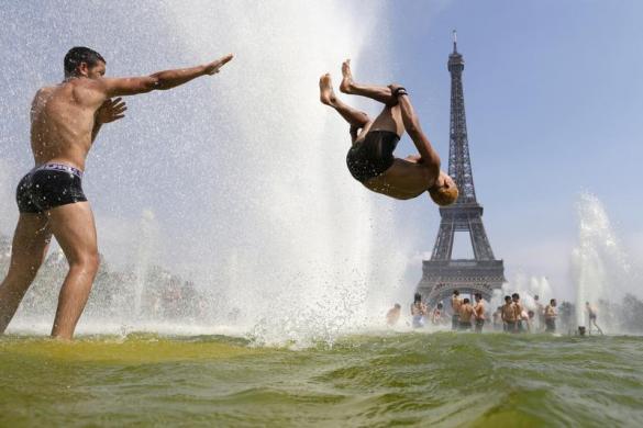 Mọi người tắm mát trên đài phun nước ở quảng trường Trocadero trước tháp Eiffel tại Paris, Pháp, khi nắng nóng vẫn tiếp diễn.
