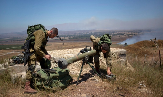 Các binh sĩ Israel đang chuẩn bị che chắn một khẩu súng phóng rocket tại biên giới với Syria ở Cao nguyên Golan.