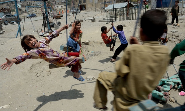 Trẻ em chơi đánh đu gần một nghĩa trang ở Kabul, Afghanistan.