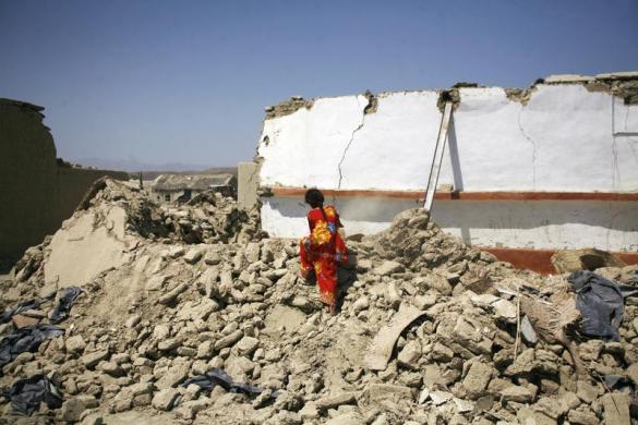 Một nạn nhân sống sót đang tìm kiếm những thứ còn dùng được trong ngôi nhà đổ nát sau trận động đất ở thị trấn Awaran, Pakistan.