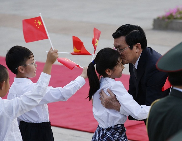 Chủ tịch nước Trương Tấn Sang ôm hôn một bé gái đang vẫy cờ trong lễ đón tiếp diễn ra tại Đại lễ đường Nhân dân Bắc Kinh, Trung Quốc.