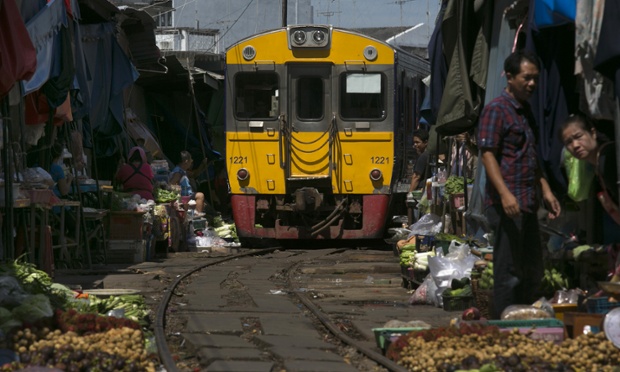 Tàu hỏa đi qua một khu chợ trên đường ray ở Maeklong, Thái Lan.