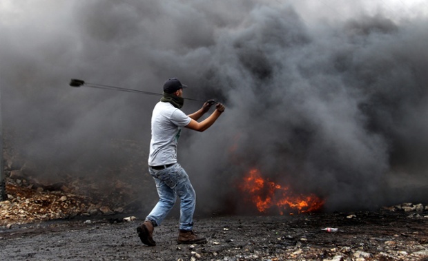 Một người biểu tình Palestin dùng dây cao sú để ném đá vào các binh sĩ Israel để phải đối xây dựng khu định cư của người Do Thái gần Nablus, Bờ Tây.