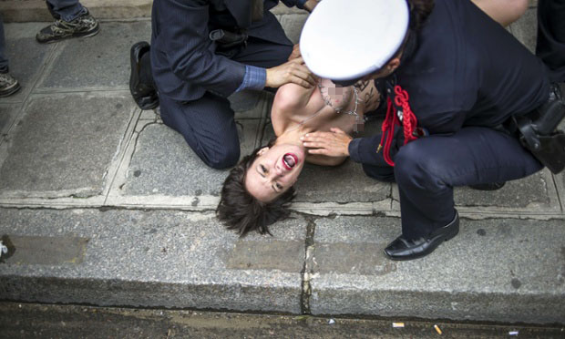 Cảnh sát bắt giữ một người đẹp ngực trần của nhóm FEMEN biểu tình bên ngoài cung điện Elysee ở Paris, Pháp, yêu cầu chính quyền Tunisia trả tự do cho một thành viên của nhóm này là Amina Sboui.