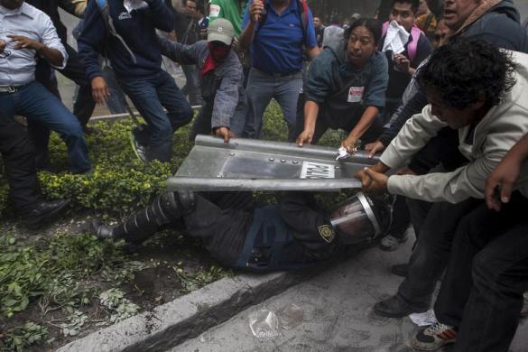 Những người biểu tình kéo khiên của một cảnh sát chống bạo động ở Mexico City, Mexico.