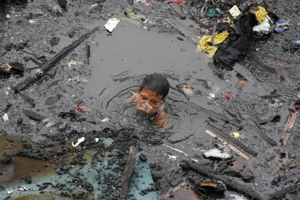 Một người đàn ông cố gằng tìm những đồ còn dùng được sau khi hàng loạt ngôi nhà bị cháy rụi tại khu ổ chuột ở Manila, Philippines.