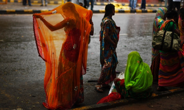 Một phụ nữ chỉnh trang phục xari truyền thống sau khi bị ướt do trời mưa ở New Delhi, Ấn Độ.