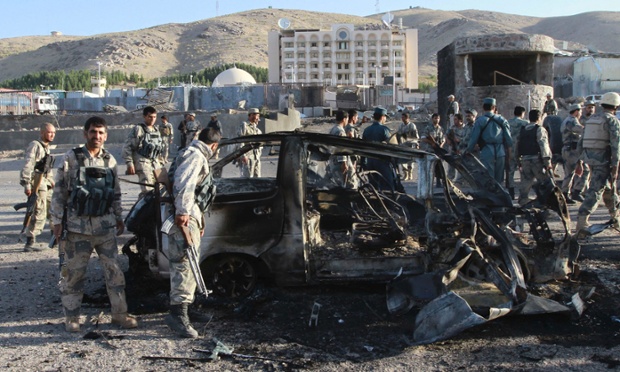Lực lượng an ninh kiểm tra một chiếc ô tô bị phá hủy trong vụ đánh bom tự sát ngoài lãnh sự quán Mỹ ở tỉnh Herat, Afghanistan.