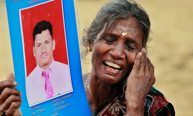 Người mẹ khóc trong khi cầm tấm ảnh của đứa con trai mất tích trong cuộc biểu tình ở Jaffna, Sri Lanka.