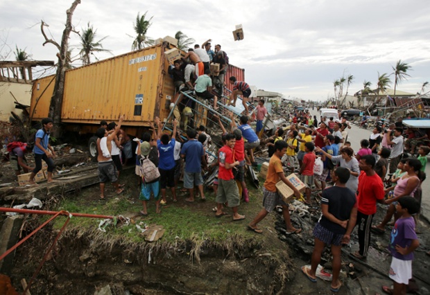Người dân tranh cướp hàng hóa từ một chiếc container bị siêu bão Haiyan đánh trôi dạt vào thành phố Tacloban, Philippines.