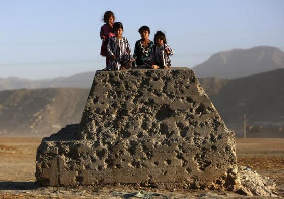 Trẻ em đứng trên tảng bê tông đầy vết đạn Kabul, Afghanistan.