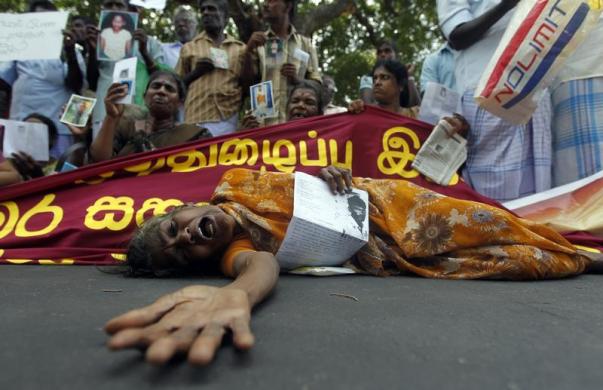 Một phụ nữ nằm khóc trên đường phố ở Jaffna, Sri Lanka, trong khi cầm bức ảnh của người thân mất tích trong cuộc chiến tranh chống nhóm Những con hổ giải phóng Tamil.
