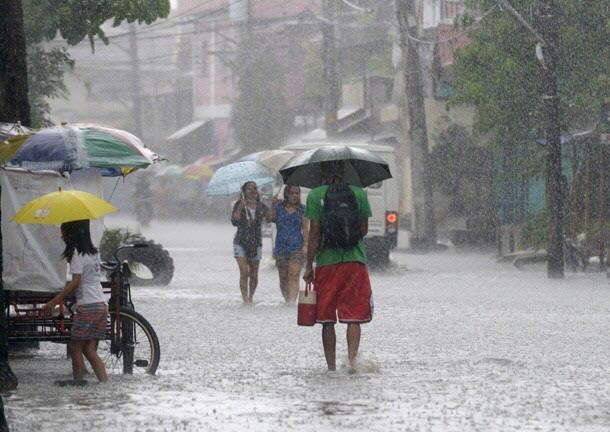 Người dân lội trên đường phố ngập lụt dưới trời mưa lớn gây ra bởi siêu bão Utor ở ngoại ô Manila, Philippines.