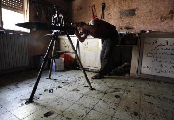 Một chiến binh của lực lượng phiến quân lắp ráp rocket trong nhà máy sản xuất vũ khí ở Aleppo, Syria.