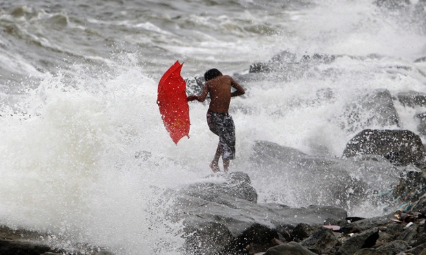 Một cậu bé chơi với sóng biển trên đê chắn sóng ở thành phố Manila, Philippines.