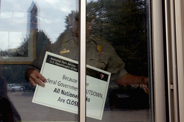 	Một nhân viên treo biển đóng cửa trên cửa sổ phòng bán vé tham quan Đài tưởng niệm Chiến tranh Thế giới thứ Hai ở Washington D.C.