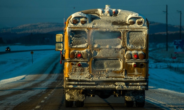 Xe bus trường học di chuyển trên đường dưới nhiệt độ lạnh -25 độ C ở Cochrane, Canada.